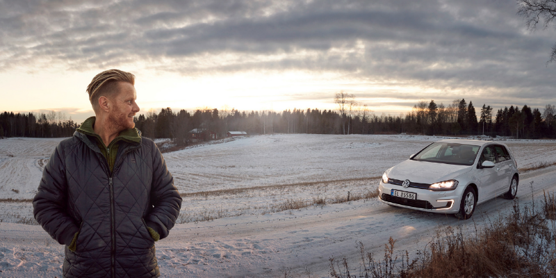 Ginge is on a dirt road, in the background stands his e-Golf