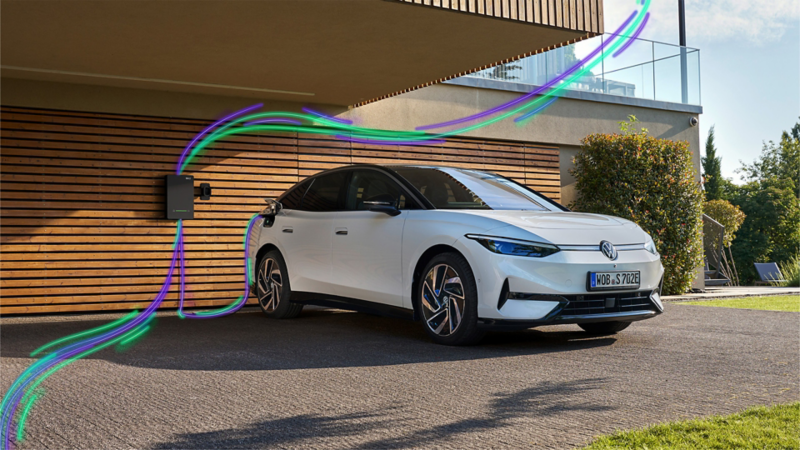 ID.7 charging at a wallbox in front of the garage of a modern residential building.