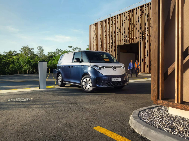A VW ID. Buzz Cargo parked by a home charger