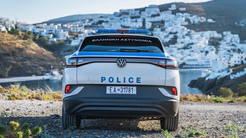 Das erste elektrische Polizeiauto von VW steht in der Sonne von hinten.