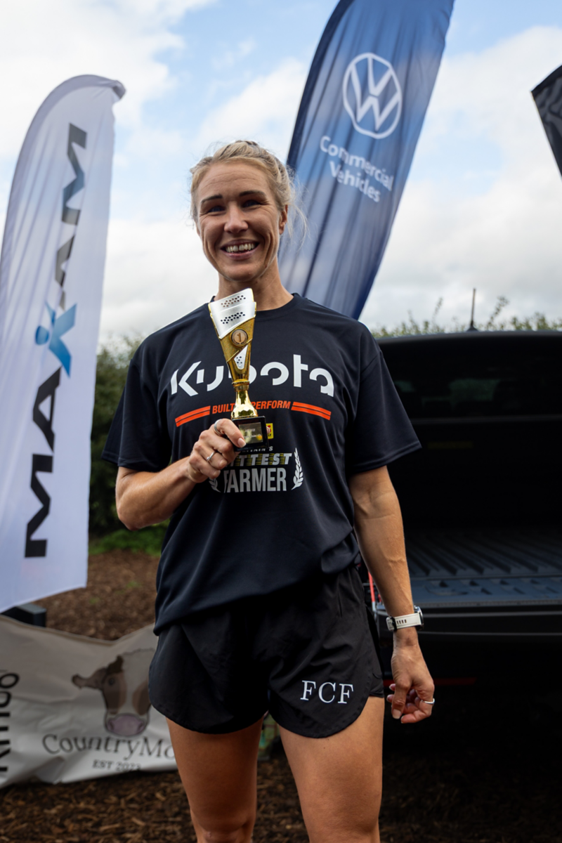 a woman standing proudly holding a trophy
