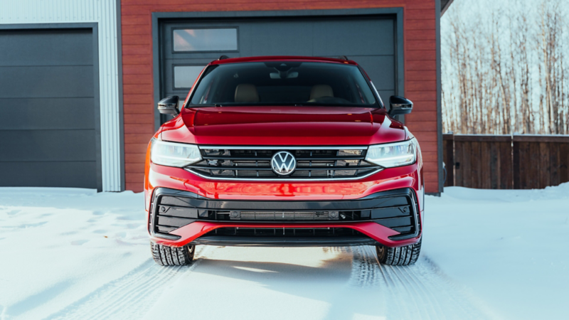 Vue de face rapprochée d'un Volkswagen Tiguan rouge stationné dans la neige.