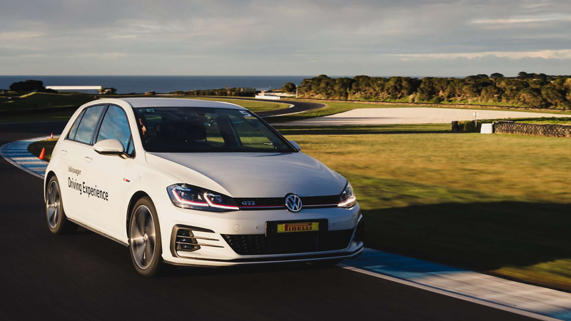 White Volkswagen Golf GTI driving on racetrack