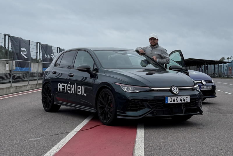 Fabian står vid passagerardörren på en svart Volkswagen.