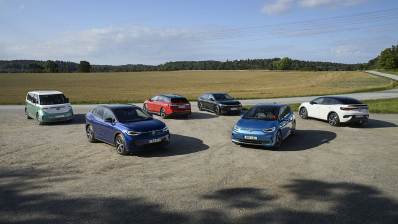 ID.-familjen står parkerade på en grusplan med en åker i bakgrunden, från vänster: ID. Buzz, ID.4, ID.7 Tourer, ID.7, ID.3 och ID.5.