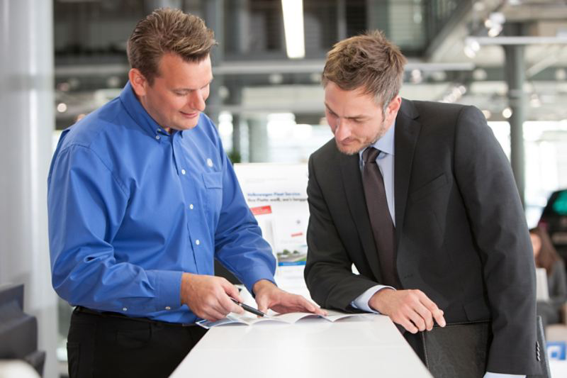 A man in a suit talking to a VW employee about PCP finance