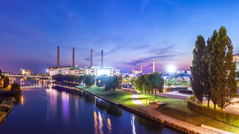 Blick über Mittellandkanal auf die beleuchtete Autostadt und das Volkswagen Werk am Abend