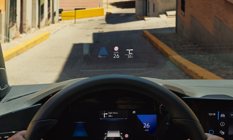 Blick auf Straße aus der Sicht des Fahrers, auf der Frontscheibe des VW Golf Variant ist das optionale Head-up-Display eingeblendet.