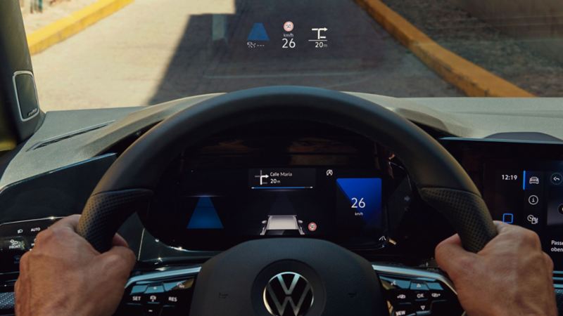 Vue à travers le pare-brise d'une VW Golf depuis la place conducteur, avec l'affichage tête haute activé.