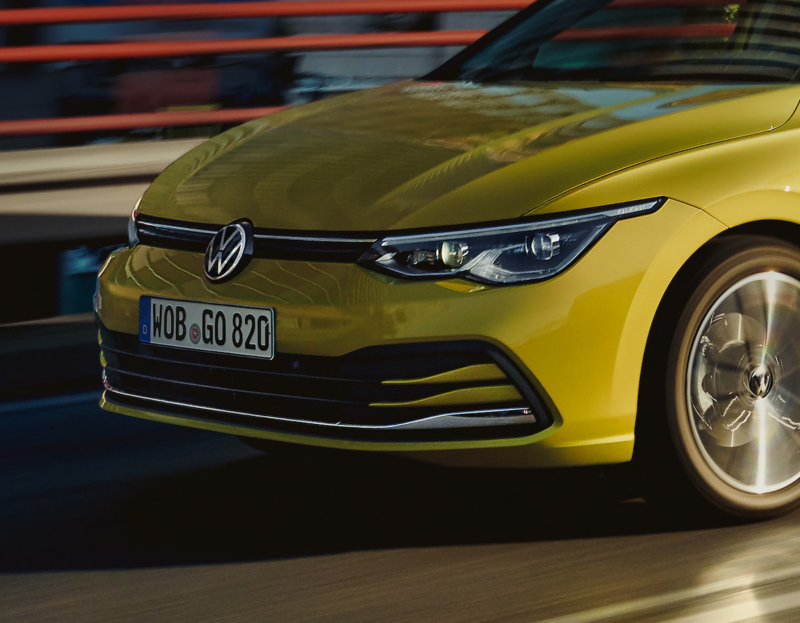 Zbliżenie na maskę Volkswagena Golfa w kolorze żółtym. 