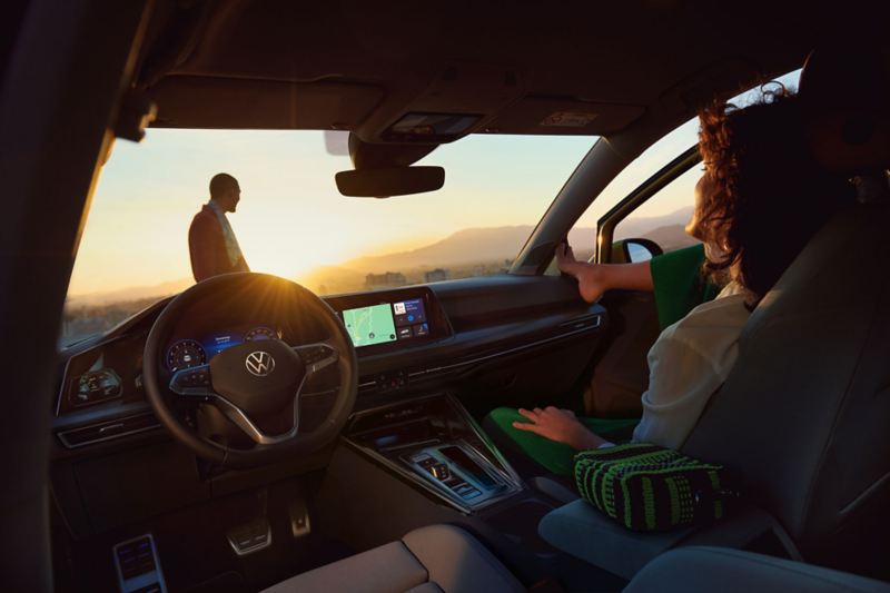 Une femme détendue sur le siège passager de la VW Golf.