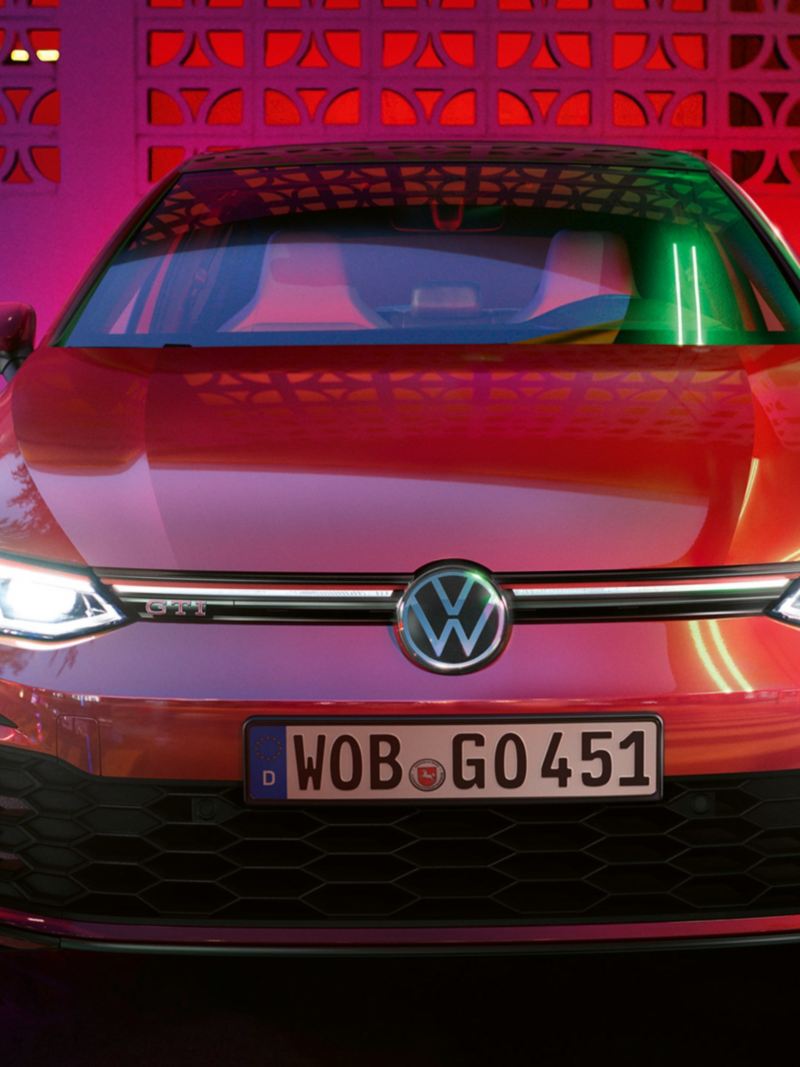 Frontansicht VW Golf GTI mit leuchtenden, optionalen IQ.LIGHT Scheinwerfern.