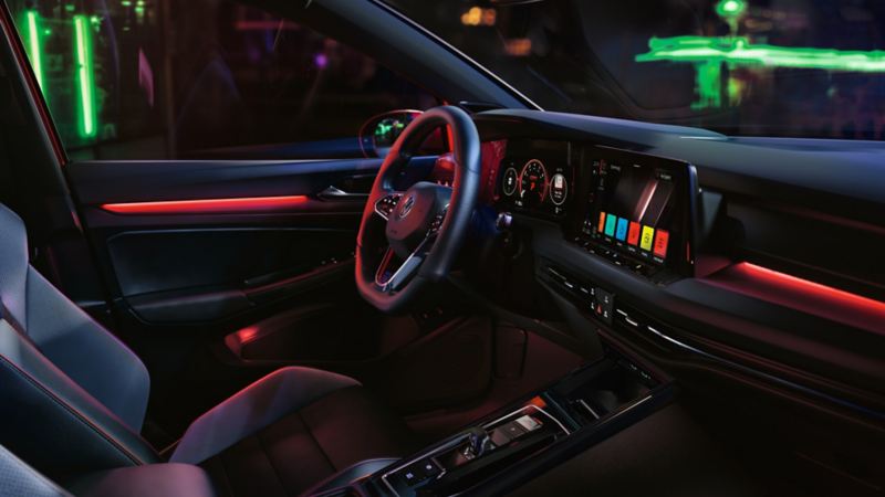 VW Golf GTI interior, cockpit view, woman operating infotainment system