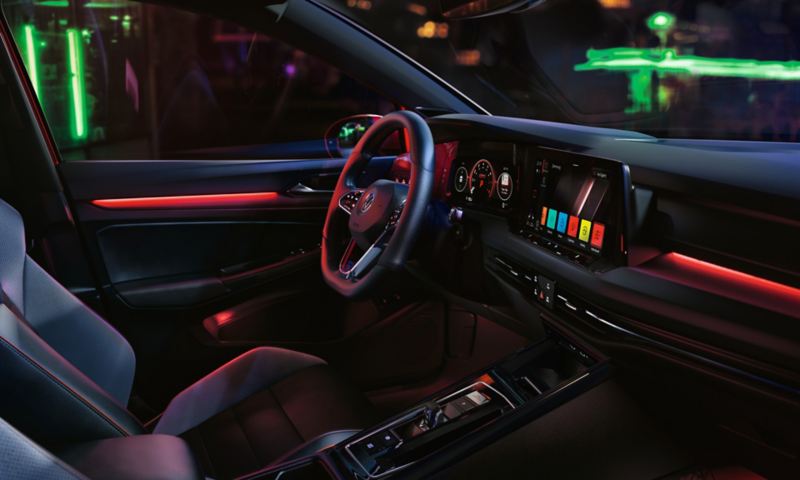 VW Golf GTI interior, cockpit view, woman operating infotainment system