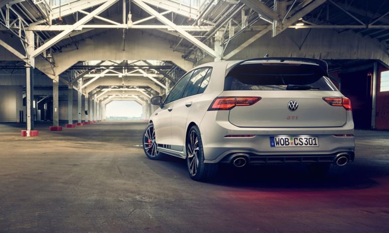Ένα λευκό VW Golf GTI Clubsport βρίσκεται σε μια άδεια αίθουσα εργοστασίου. Άποψη του πίσω μέρους. 