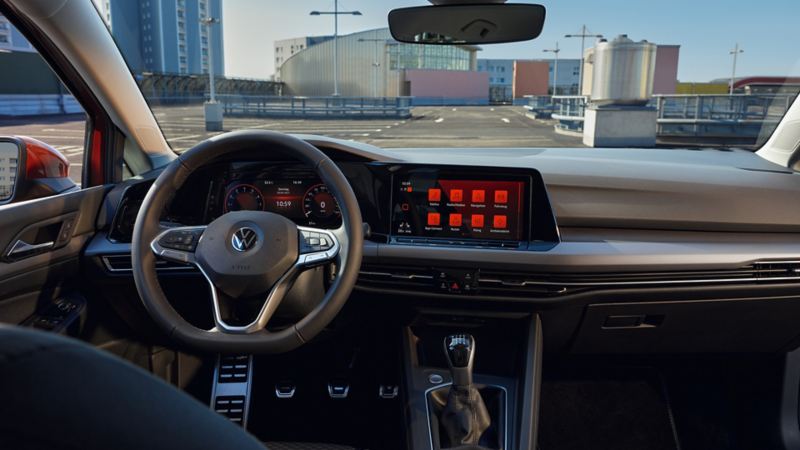 Roter VW Golf ACTIVE von innen. Blick im Cockpit auf Multifunktionslenkrad, Pedalkappen und Armaturen mit Ambientebeleuchtung
