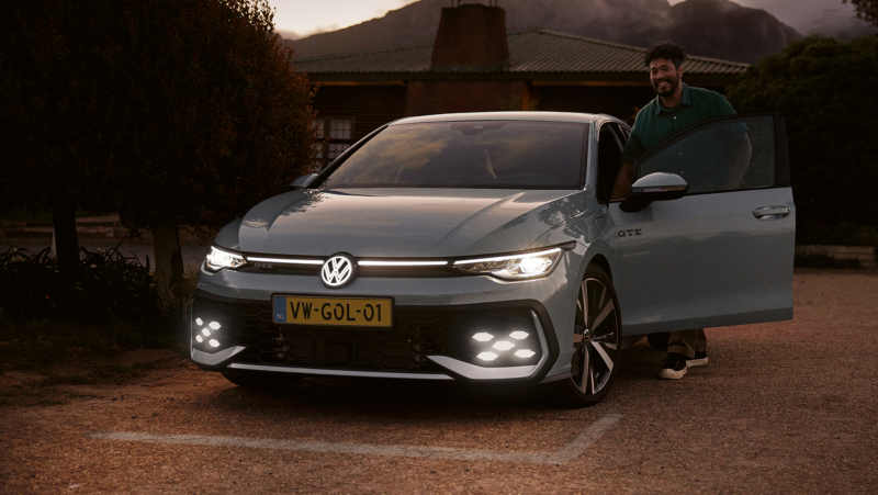 Vooraanzicht van de nieuwe Volkswagen Golf, de focus ligt op de IQ light LED matrix verlichting die aanstaat en extra opvalt door de schemering