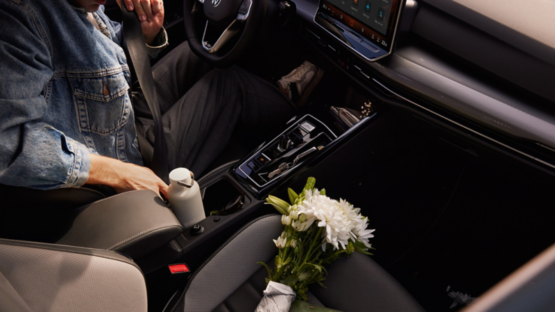 View of the front interior of a white VW Golf. The driver's door is open.