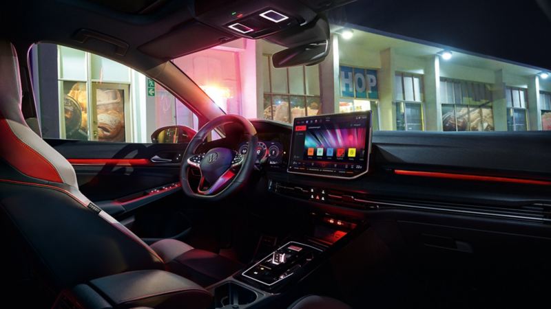 Interior view of a VW Golf GTI with ambient lighting switched on.