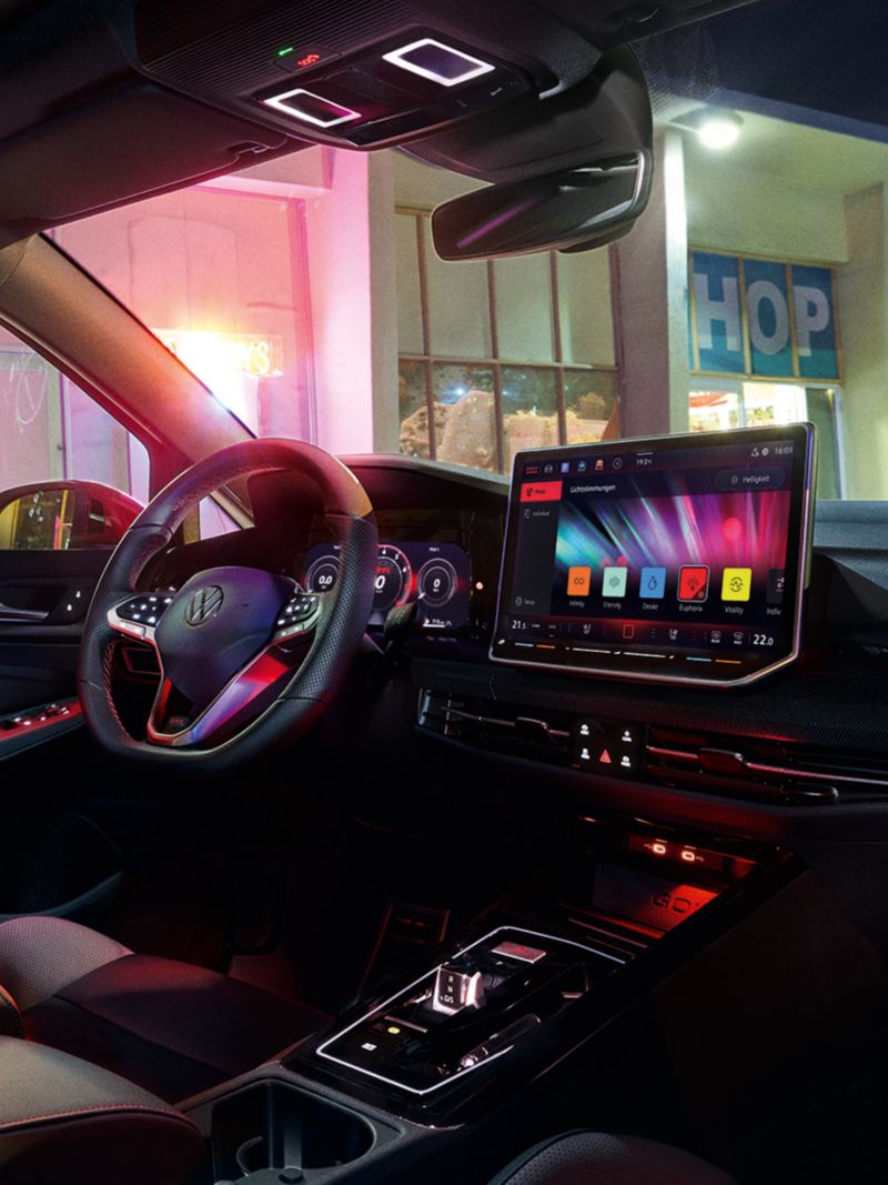 Interiörvy av en VW Golf GTI med påslagen ambientbelysning.