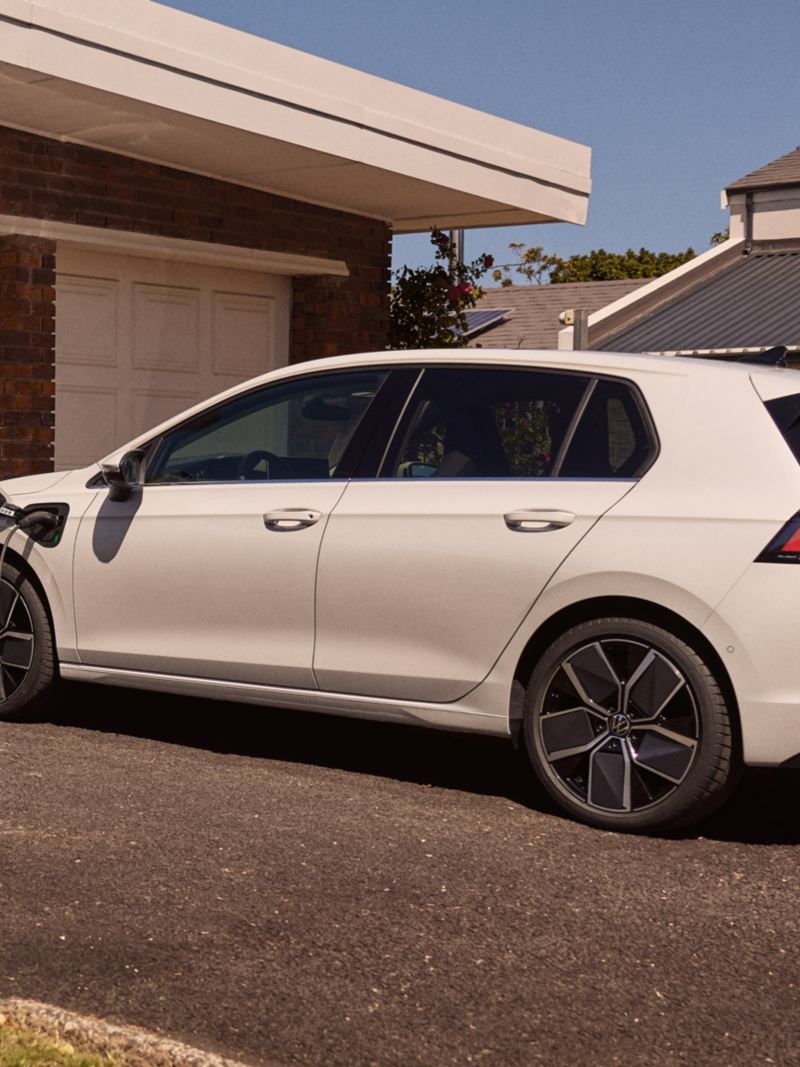 White VW Golf eHybrid charging and parked at home