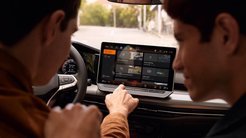 Deux hommes manipulent le système d'infodivertissement de la VW Golf.