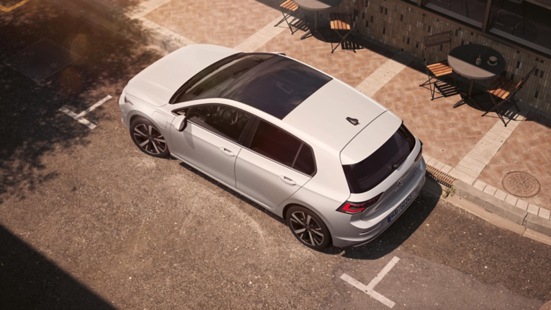 Topview of a white VW Golf with focus on the panoramic roof pop-up/sunroof.