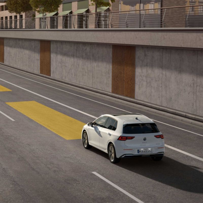 Baltos spalvos naujasis „Golf“ važiuoja link tunelio ir naudoja automatinio atstumo reguliavimo funkciją.
