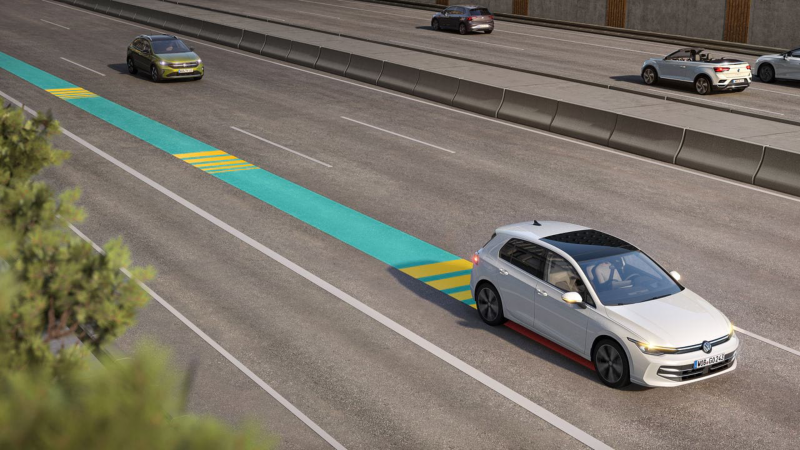 White VW Golf moving in road traffic, using Emergency Assist as shown in the picture.