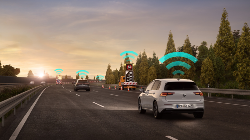 En vit VW Golf GTI kör med Varning för trafikfara påslagen.