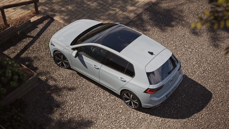 Widok z góry na nowego, białego Volkswagena Golfa GTE ze zbliżeniem na panoramiczny wysuwany/przesuwany dach.