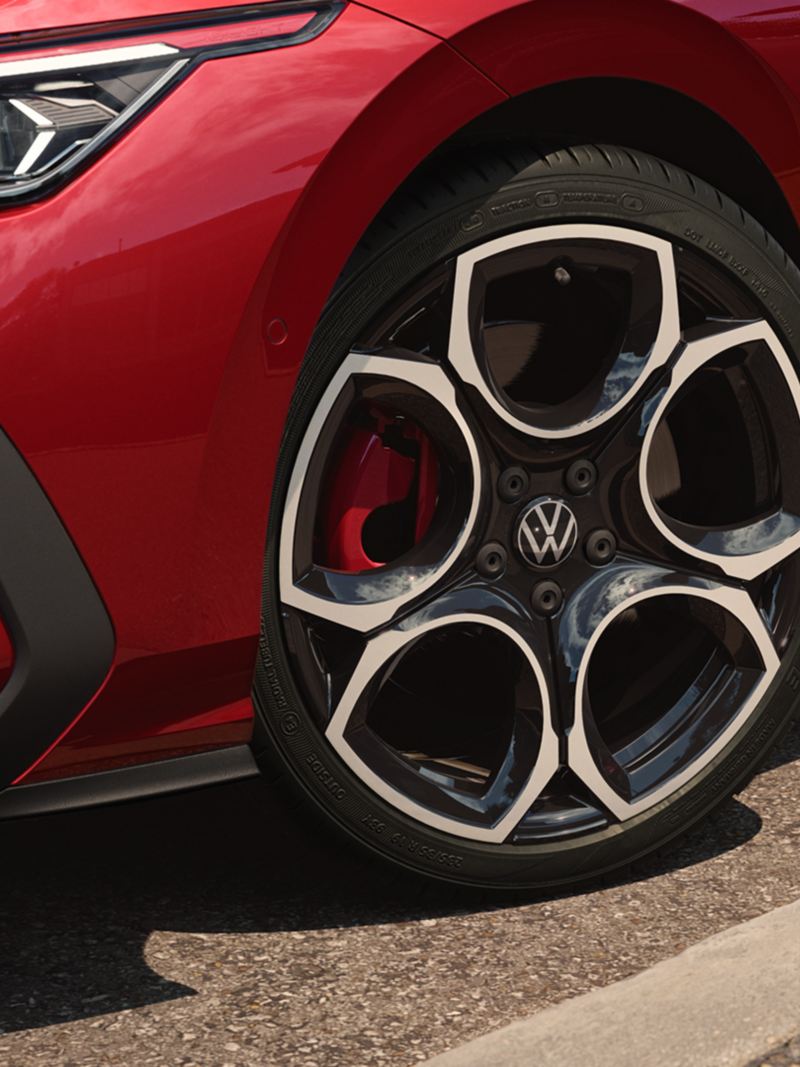 Red VW Golf GTI with focus on the rims.