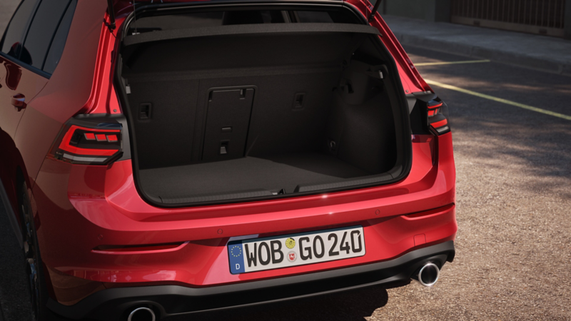 Närbild av en röd Golf GTI med öppen baklucka.