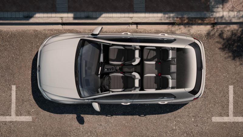 Topview auf einen weissen VW Golf mit Fokus auf das Panoramadach-Aufstell-/Schiebedach.