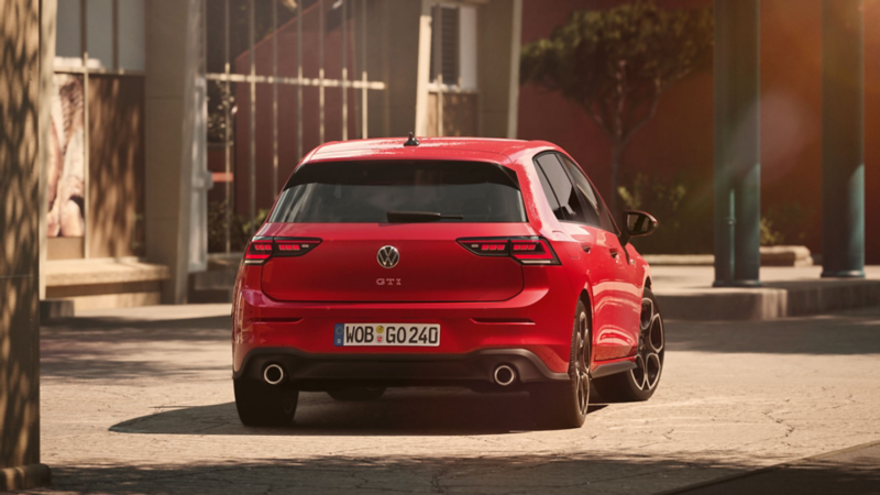 rear view of a red VW Golf GTI parked by an office building