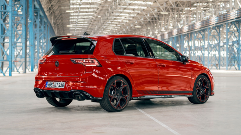Ein roter VW Golf GTI EDITION 50 steht in schräger Heckansicht in einer Industriehalle.