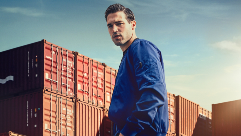 Un homme en veste bleue entouré d'immeubles