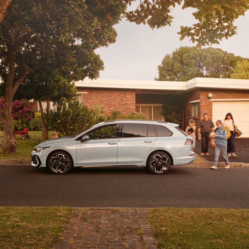 Une Golf SW de profil, garée le long d'une maison.