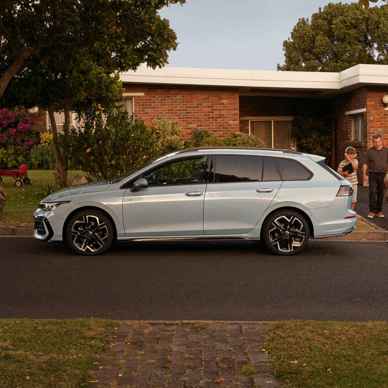 Une Golf SW de profil, garée le long d'une maison.