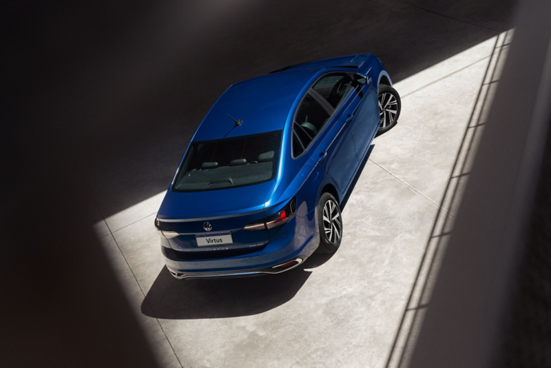Vista aérea de un Volkswagen Virtus azul estacionado en un espacio iluminado, resaltando su diseño elegante y moderno.
