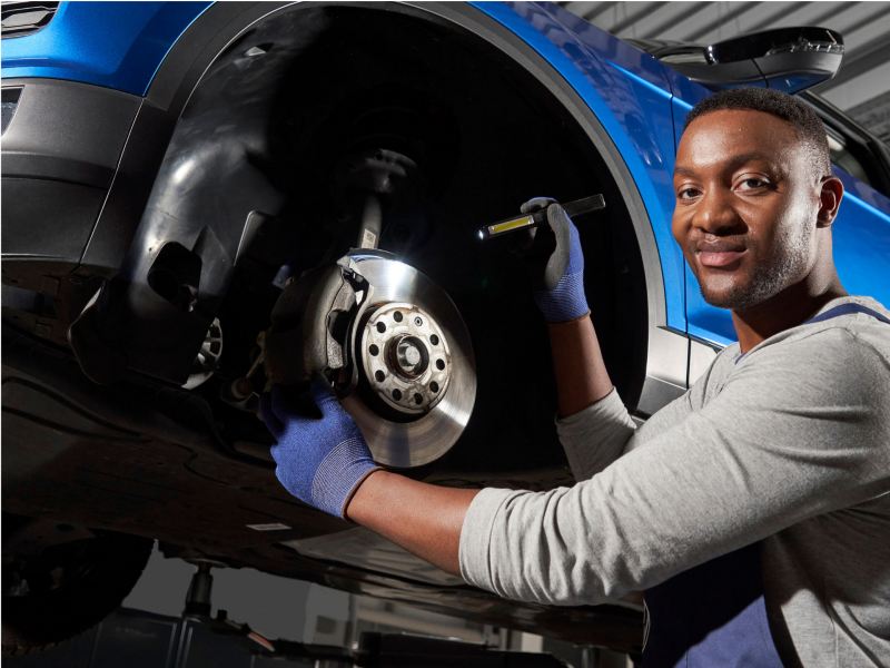 Técnico de servicio de Volkswagen trabajando en una rueda.