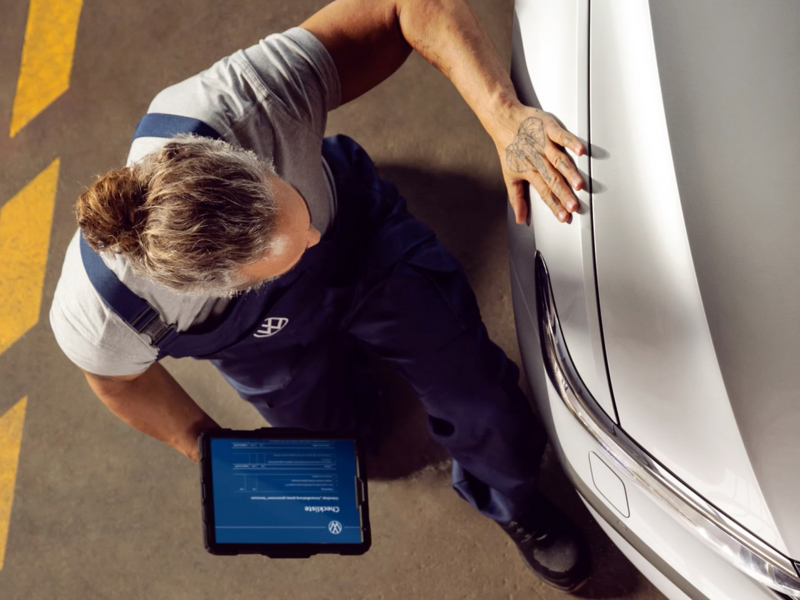 Mechanic working on car holding screen