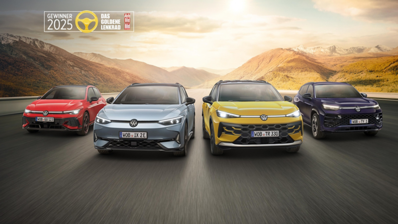 Vier Volkswagen Modelle sind die Gewinner des goldenen Lenkrads und fahren im Sonnenaufgang nebeneinander auf der Straße durch die Landschaft.