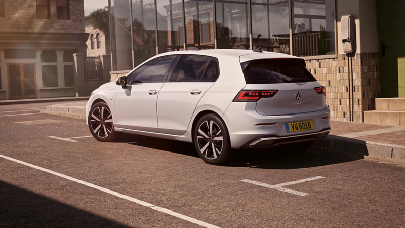 Une Golf blanche est garée au bord de la route.