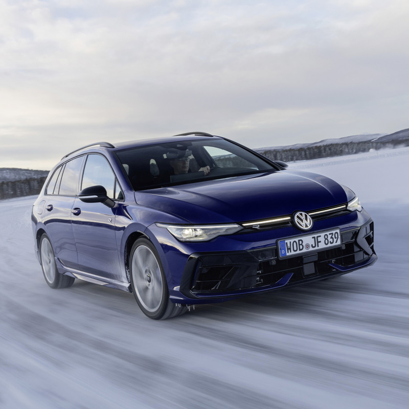 En mörkblå VW Golf körandes på vinterväglag, sedd snett framifrån