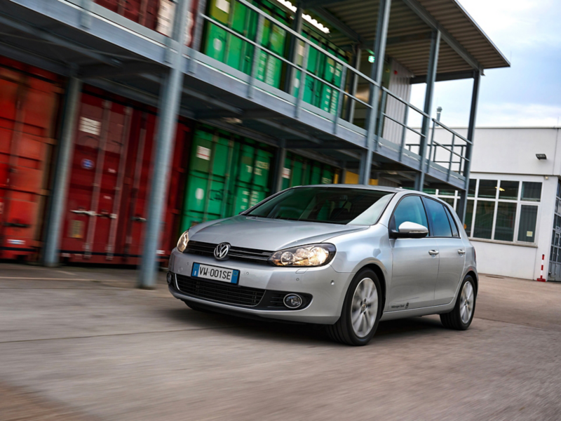 Una VW Golf 6 si muove all'interno di un'area di stoccaggio container.