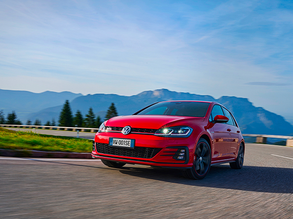Una VW Golf 7 rossa percorre una strada in montagna.