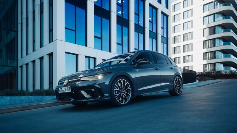 Ein weißer VW Tayron R-Line und ein dunkelblauer VW Tayron Elegance parken nahe eines Strandes.