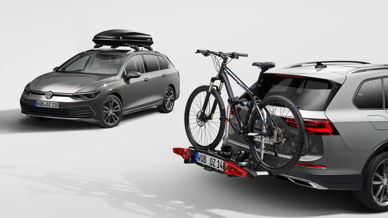 Two Volkswagen Cars in a showroom with a roof rack and bike tow storage accessory