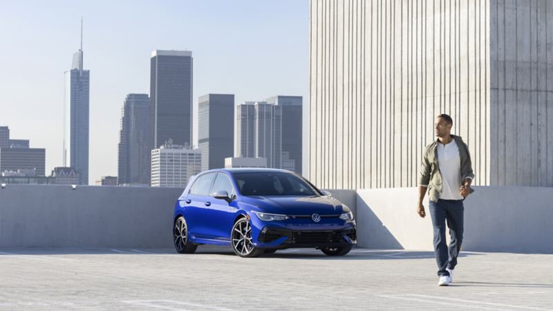 A man walking in front of a parked 2024 Golf R